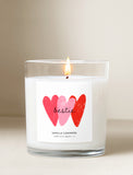 Lit Friendship Day candle in a glass jar with a white label featuring red and pink hearts and the word bestie. - Image 