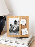 Sustainably sourced bamboo picture frame with a cork memo board, resting on a stack of books. - Image 