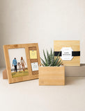 A wooden photo frame with a small cork message panel holding two pins, displayed beside a rectangular wooden planter with a small succulent and a matching wooden holiday card on a light beige background. - Image 