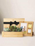 A bamboo photo frame gift set on a light beige background, featuring a rectangular bamboo box with a black ribbon, a bamboo succulent planter with green plants, and a smaller bamboo picture frame with a photo insert and sticky notes. - Image 