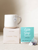 Ceramic mug, gift box and tea in front of a beige background. - Image 