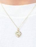 Heart necklace on white sweater. - Image 