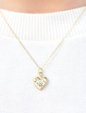 Gold heart necklace on white sweater. - Image 