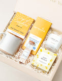 Happy Birthday gift box with a ceramic mug, herbal tea, chocolate bar, vanilla candle, and matches in a cream box. - Image 