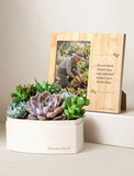 Heart-shaped succulent garden in a white box next to a bamboo photo frame with a memorial quote and garden photo. - Image 