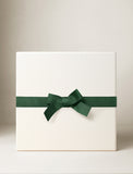 Square white gift box wrapped with a dark green grosgrain ribbon and bow. - Image 
